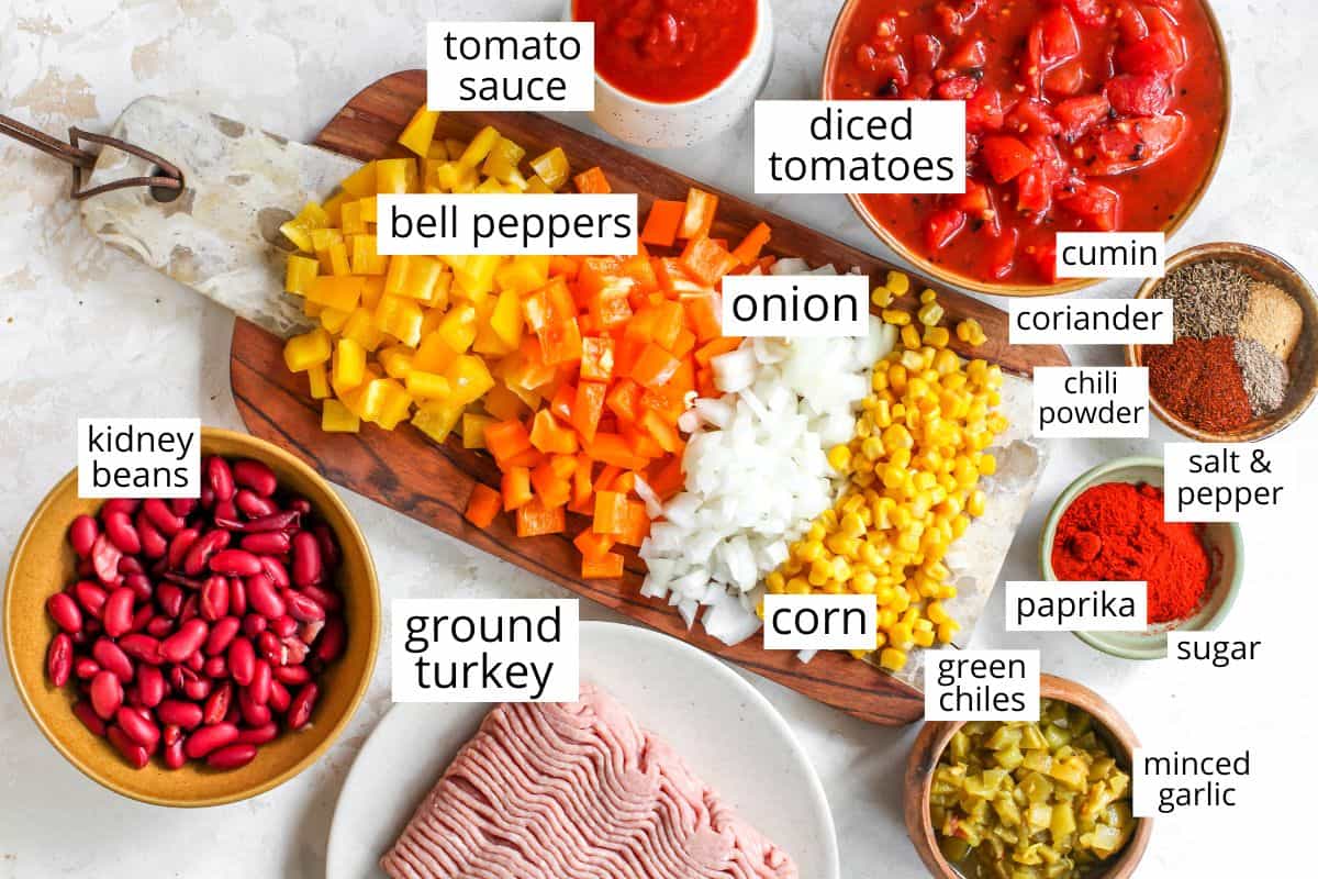 This Healthy Turkey Chili recipe is easy to make in 30 minutes on the stovetop. Turkey chili is loaded with protein and veggies and bursting with flavor thanks to a homemade spice mixture. A nutritious and cozy fall meal. Overhead view of the labeled ingredients in this turkey chili recipe