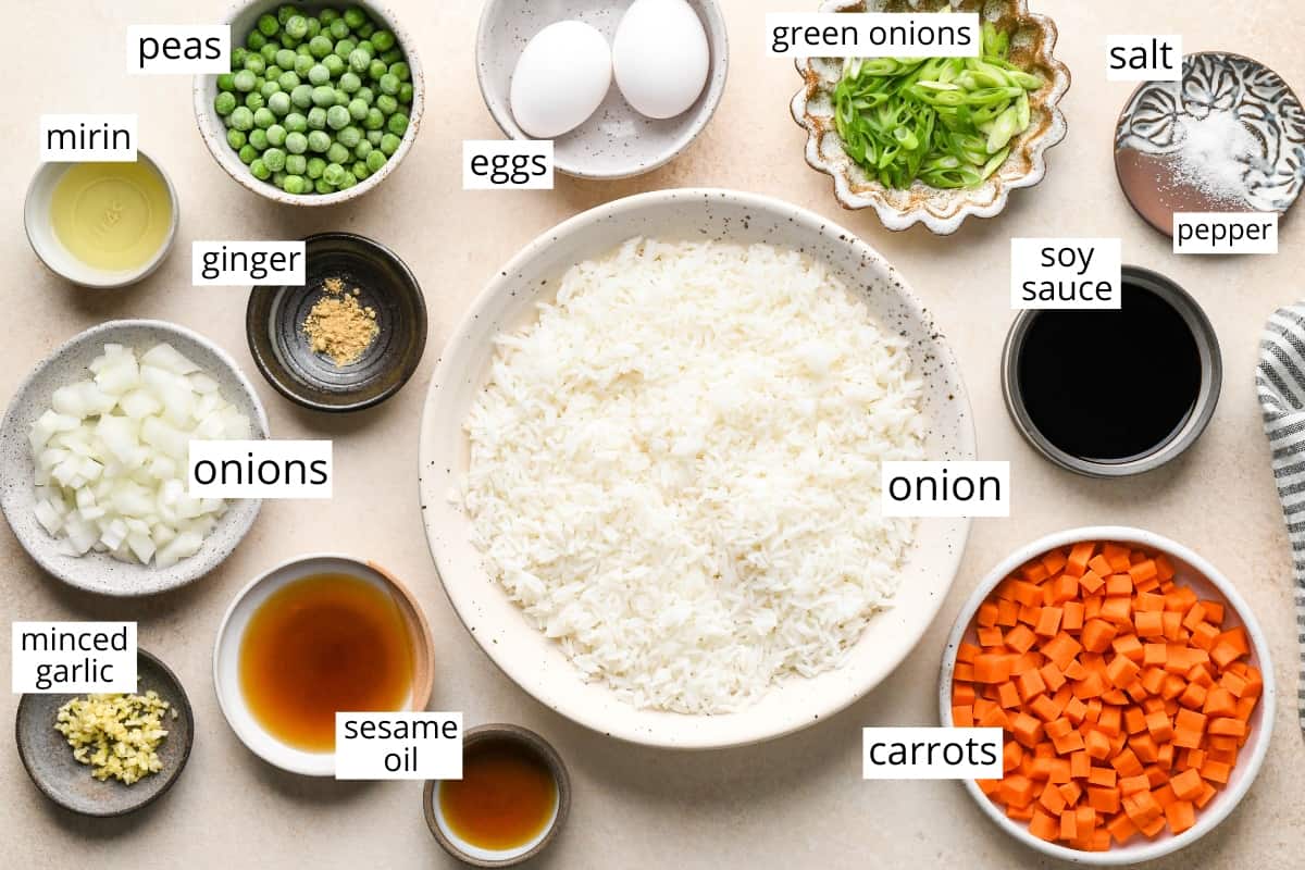 This easy vegetable fried rice recipe is better than takeout! It only takes 20 minutes to make the best fried rice recipe that's flavorful, healthy and loaded with eggs and veggies! overhead view of the labeled ingredients in this fried rice recipe