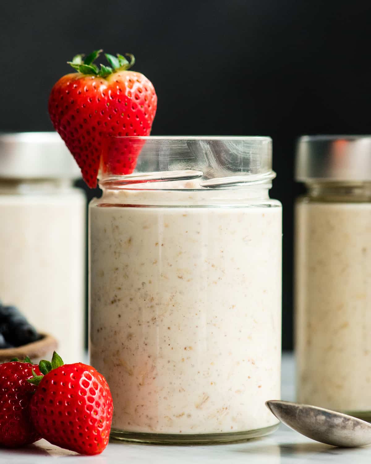 Easy Overnight Oats with Yogurt are a great healthy high-protein breakfast! This recipe only takes 6 ingredients and 5 minutes to prepare! Plus it's no-cook, gluten-free and can easily be made dairy-free! #overnightoats #oatmeal #greekyogurt #yogurt #glutenfree #breakfast #healthyrecipe #mealprep front view of three jars of yogurt overnight oats