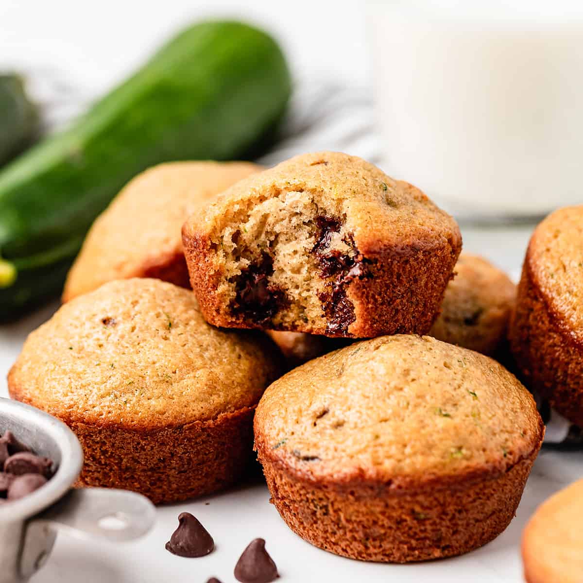 6 Zucchini Chocolate Chip Muffins, one with a bite taken out of it